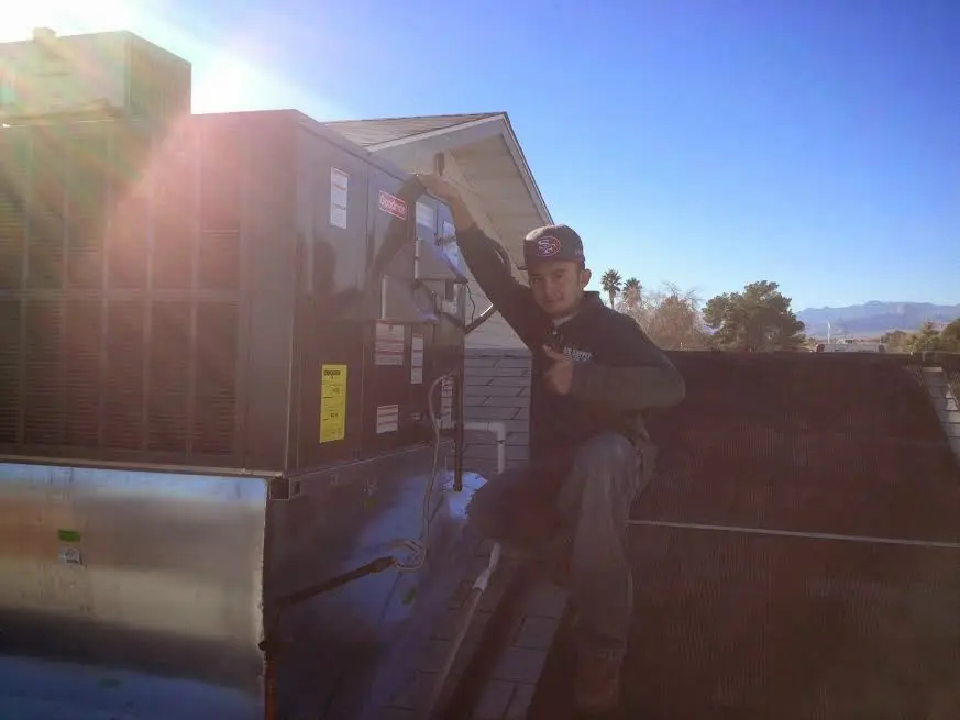 HVAC technician performing Air Duct Cleaning on a rooftop unit in Cecil